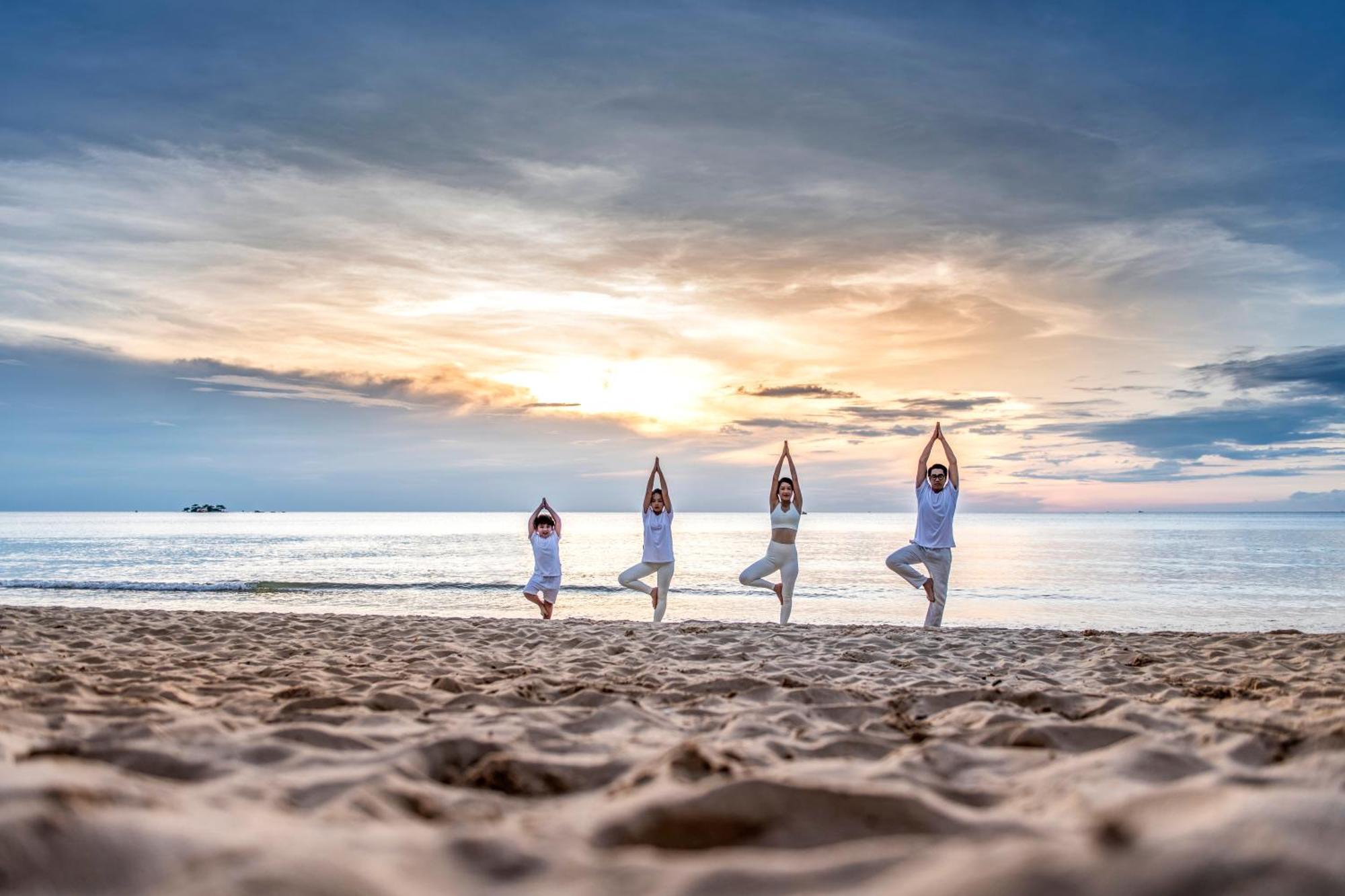 Vinpearl Resort&Spa Phu Quoc Exterior foto Family practicing yoga on the beach